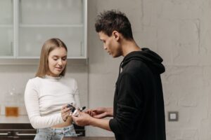 image-of-a-woman-handing-the-glucose-metre-to-a-man