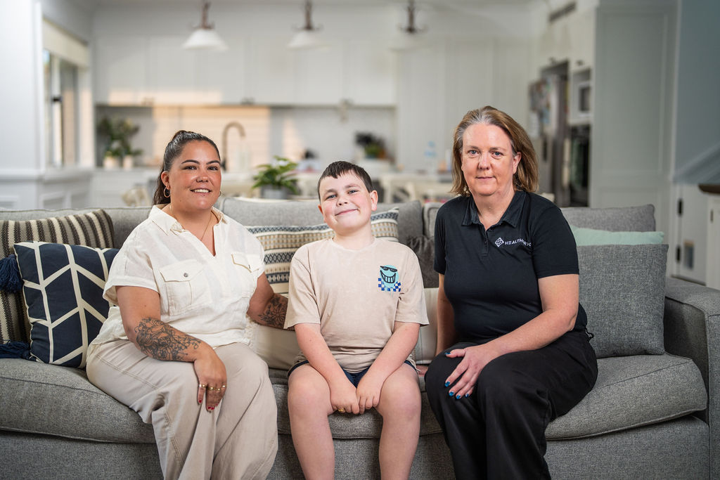 Boy sitting on the lounge between his mother and a Healthproof clinician