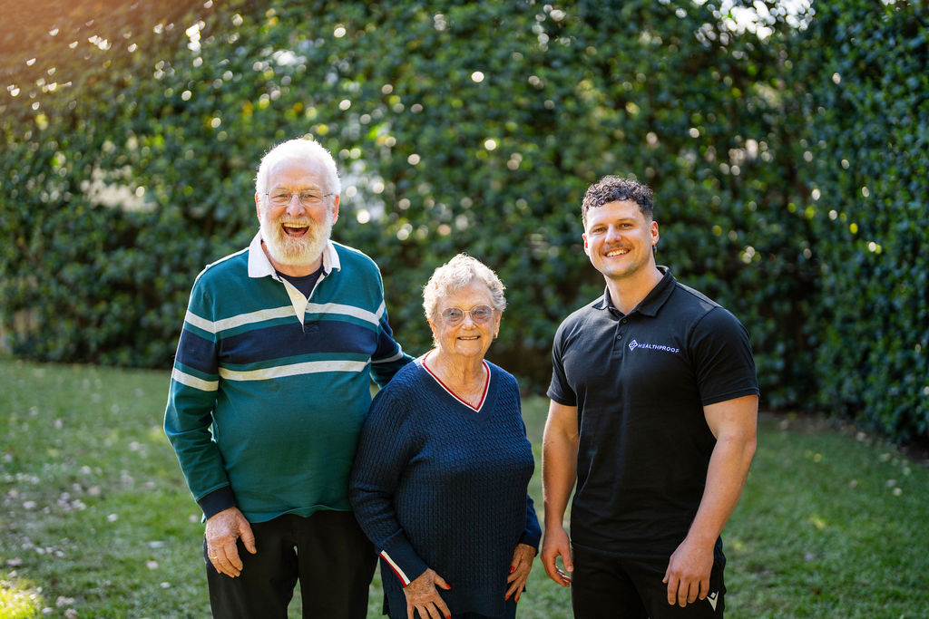 Healthproof clinician outdoors with an older couple receiving in-home allied health care