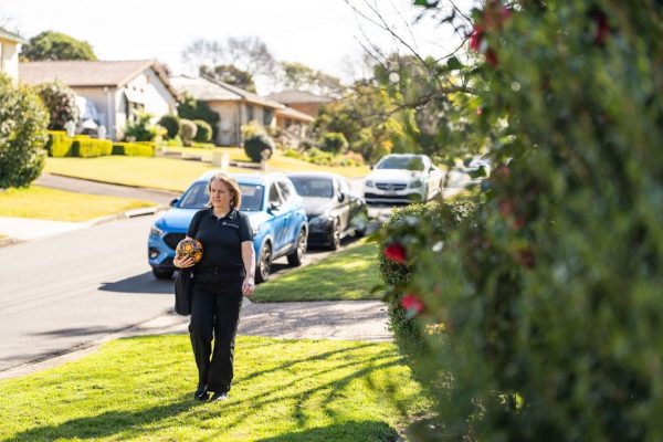 Healthproof clinician walking up a suburban driveway to a home visit